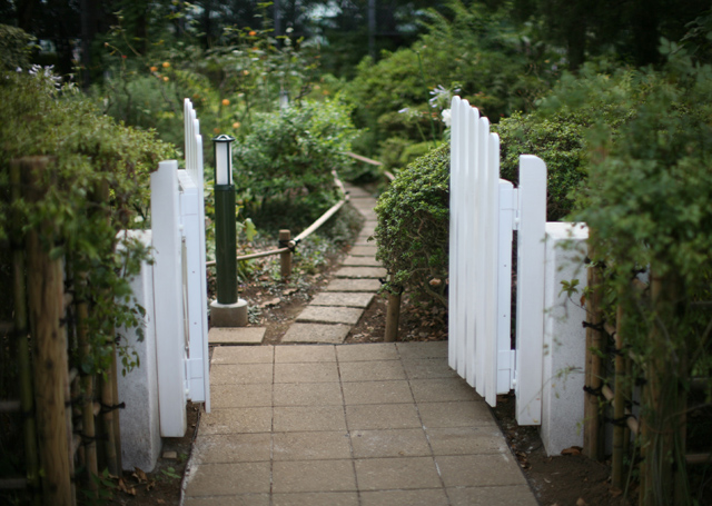 旧庭園入口、門扉もかつて使用していたものをできるだけ忠実に再現した。公園内にはデザインを統一した門扉を4ヶ所に設置している。庭園内には以前使われていた平板の飛石の再利用や、庭園の趣を妨げない人止柵を設置。 (写真提供:栗原秀幸氏)